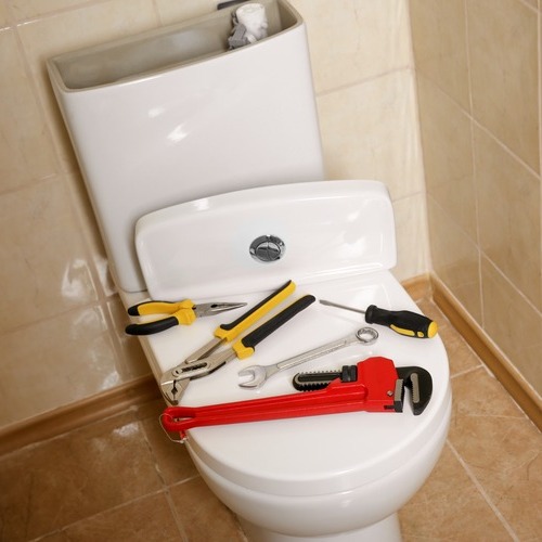 plumbing tools on a toilet seat
