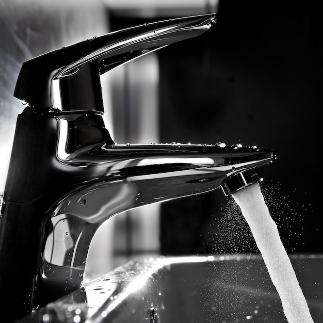 A sparkling new chrome faucet running fresh water.